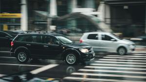 Black SUV navigating through a city intersection, emphasizing the importance of vehicle safety and smooth driving after collision repairs at 360 Collision.