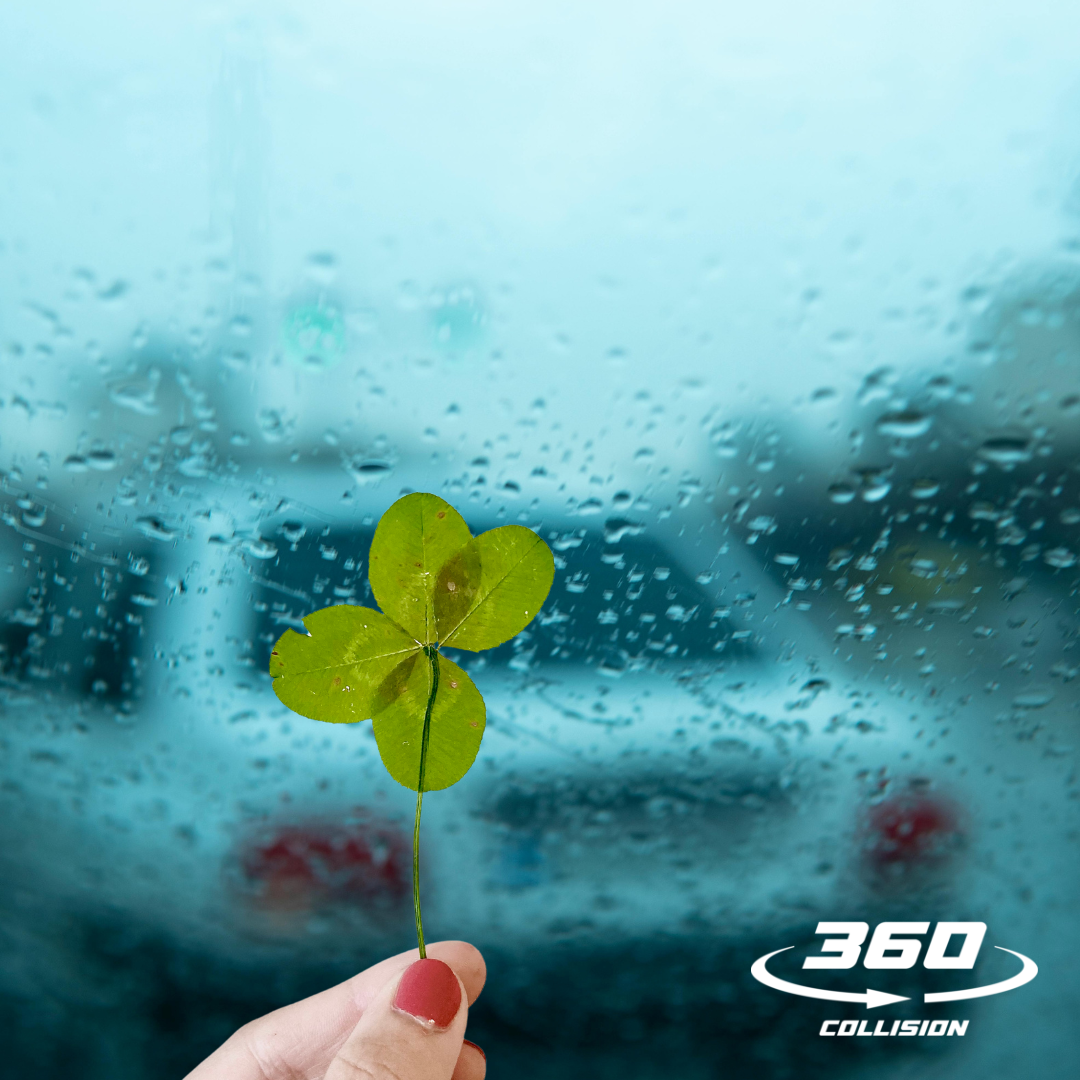 Hand holding a four-leaf clover against a rain-soaked window, with a blurred car in the background and the 360 Collision logo prominently displayed, symbolizing hope and protection from hail damage.